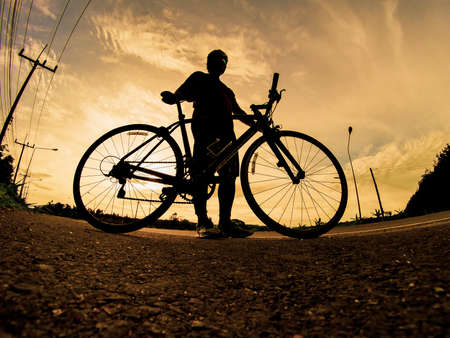 People exercise on bicycles in the evening. Sport in Nature background. The image of a cyclist in motion in the background in the eveningの写真素材
