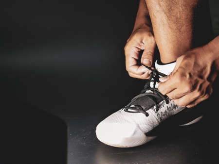 Close-up of athletes tying shoe straps in preparation for training after the COVID-19 crisis.の写真素材