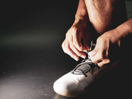 Close-up of athletes tying shoe straps in preparation for trainingの写真素材