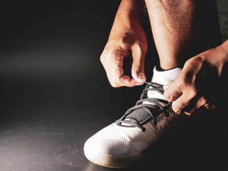 Close-up of athletes tying shoe straps in preparation for trainingの写真素材