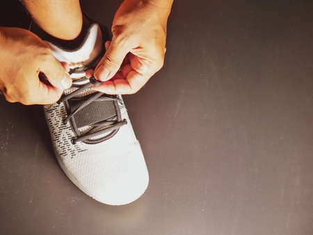 Close-up of athletes tying shoe straps in preparation for trainingの写真素材