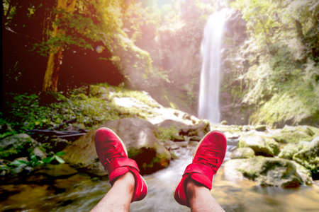 The red tourist shoes happily extended into the beautiful scenery.の写真素材