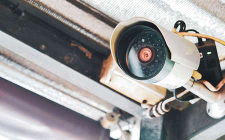 Close-up view of the front of the CCTV camera with clear lens mounted on the wall for security.