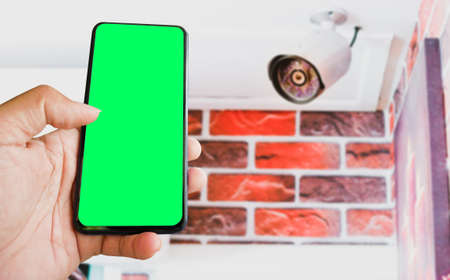 cctv and mobile with green blank screen or copy space to put the desired content in your project. cctv on the wall for security.の写真素材