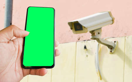 cctv and mobile with green blank screen or copy space to put the desired content in your project. cctv on the wall for security.の写真素材