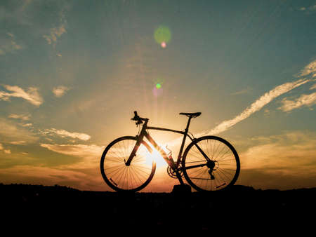 Silhouette of a bicycle parked on the beach in the evening. Silhouette of with bicycles at sunset. beautiful landscape image with Bicycle at sunsetの写真素材