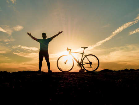 Silhouette of cyclists with bicycles at sunset. silhouette of a person with a bike at sunset....
