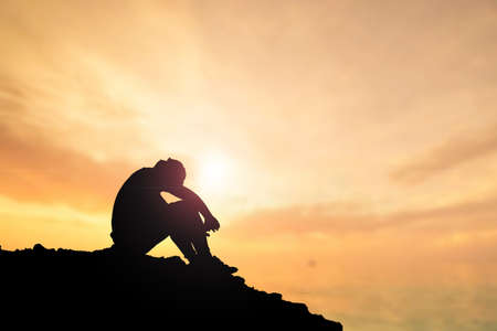 An unemployed man sat with his head down in despair.の写真素材