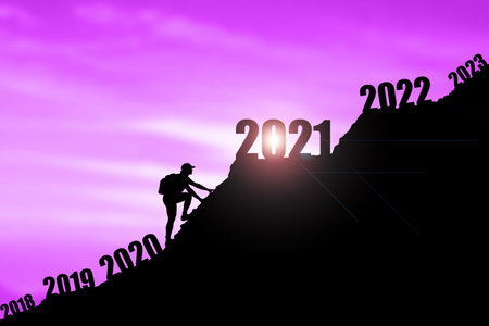 Man climbing mountains and going through and changing 2019 ,2020 to enter 2021. Happy New Year 2021 concept. Happy new year and holiday concept. Vintage tone filter effect color style. Success new year concept.の写真素材