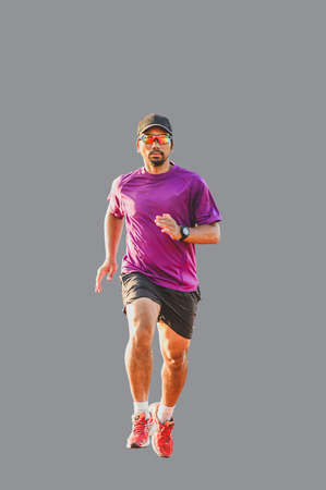A runner, a middle-aged Asian man wearing glasses. wearing a hat on a colored backgroundの写真素材