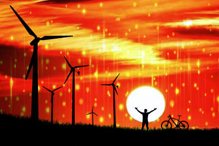 Silhouettes of wind turbines power and high-voltage poles in a field at sunset.の写真素材