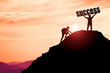 The man raised his hand happily on the top of a high mountain. successful in doing business. A man...