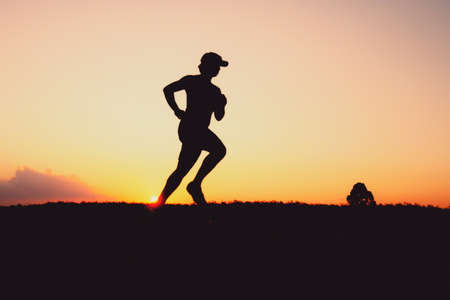 Silhouette of a man practicing for a run in the evening. Training and running conceptsの写真素材