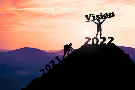 The man raised his hand happily on the top of a high mountain. successful in doing business. A man...