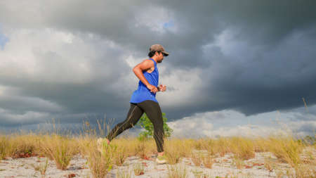 Male runner training on the sand. A lone runner training during the COVID-19 crisis
