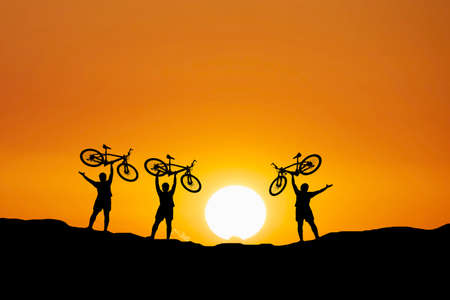 Silhouettes of touring cyclists practicing in the mountains offer beautiful views in the...