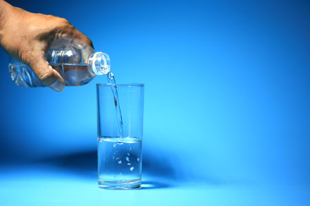 Clean drinking water in a glass on a blue background. healthy drinking water concept