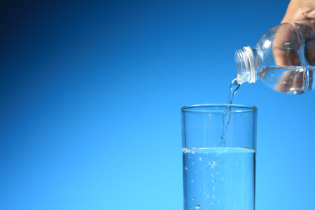 Clean drinking water in a glass on a blue background. healthy drinking water conceptの写真素材
