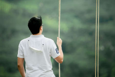 The hand of a man in a white shirt standing lonely alone on the mountain