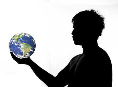 A half-shadow side view of a man holding a globe and staring. silhouette of a man on a white backgroundの写真素材