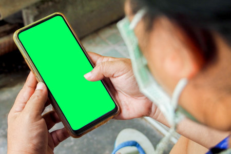cell phone blank screen mockup. background empty space for advertise. Woman hand holding the black smartphone with blank screen and modern frameless design.の写真素材