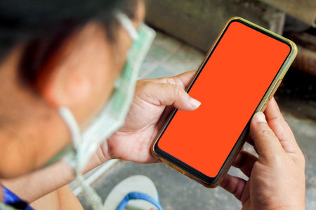 cell phone blank screen mockup. background empty space for advertise. Woman hand holding the black smartphone with blank screen and modern frameless design.の写真素材