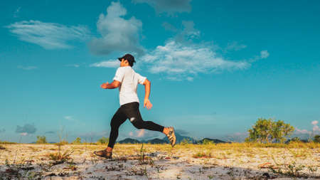 An Asian man practicing running in the sand on a nice day. Training and Exercise Conceptsの写真素材