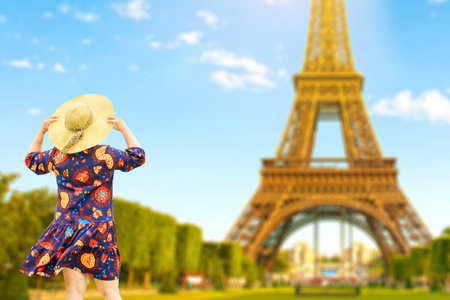 A woman in a hat is raising her hand happily with the beautiful view. happy touristsの写真素材