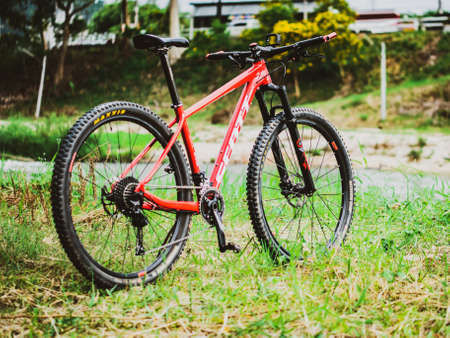 On August 19, 2021, Ban Na San District Surat Thani Province Thailand. A red mountain bike parked in a meadow. A cyclist's red bicycle parked in the meadow.のeditorial素材