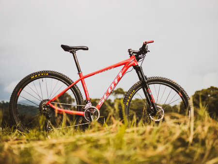 On August 19, 2021, Ban Na San District Surat Thani Province Thailand. A red mountain bike parked in a meadow. A cyclist's red bicycle parked in the meadow.のeditorial素材
