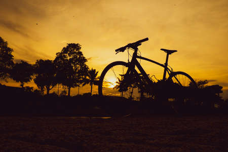 bike parked in the meadow in the evening. bicycle silhouetteの写真素材
