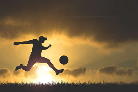 Silhouette of soccer players playing soccer in the evening. Fun concept of playing football.の写真素材