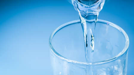 studio shot Clean drinking water poured into glass and natural blue background. healthy drinking...