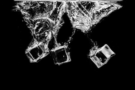 Ice cubes in water on studio dark background. The concept of freshness with coolness from ice cubes.の写真素材