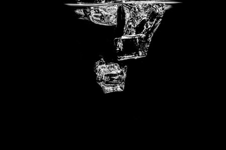 Ice cubes in water on studio dark background. The concept of freshness with coolness from ice cubes.の写真素材