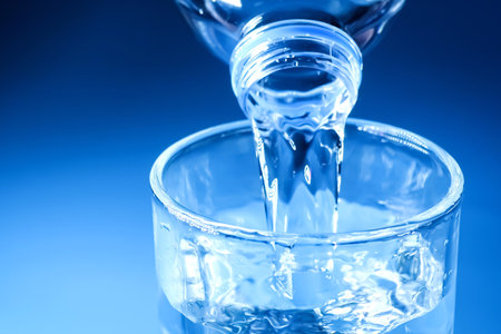 studio shot Clean drinking water poured into glass and natural blue background. healthy drinking...