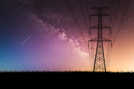 Captivating image of the Milky Way and a shooting star in the night sky, with an electricity pylon silhouetted against a colorful sunset.の写真素材