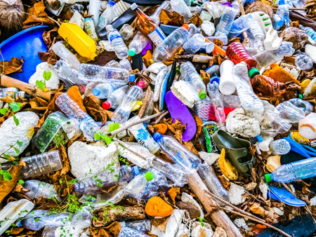 A detailed image of plastic waste and pollution, showcasing discarded bottles and trash in a natural environment.の写真素材