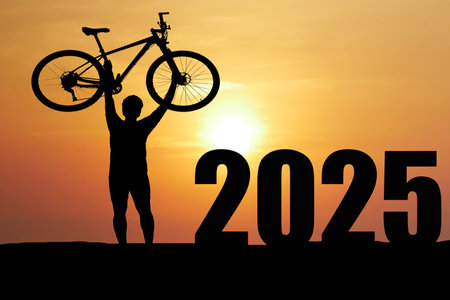 A triumphant cyclist raises their bike in front of a 2025 sign during a stunning sunset, symbolizing...
