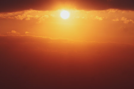 Captivating sunset with golden hues and dramatic clouds, perfect for conveying tranquility and beauty.の写真素材