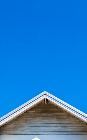 A minimalist view of a building's roof set against a vibrant blue sky, showcasing modern architectural design.の写真素材