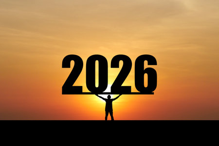 A silhouette of a person holding a large "2026" sign against a dramatic sunset, symbolizing new beginnings and future aspirations.の写真素材