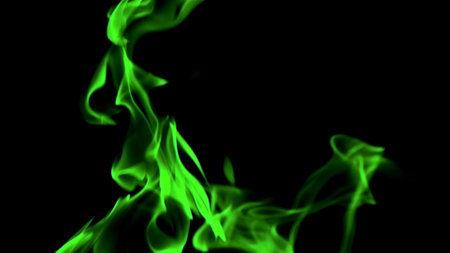 Bright green flames against a dark backdrop, perfect for themes of mystery, energy, or fantasy.の写真素材