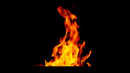 Dynamic close-up of bright orange flames against a black backdrop, showcasing the energy and movement of fire.の写真素材