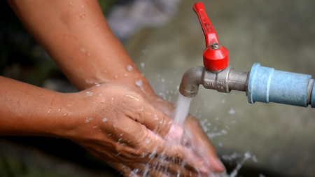 Closeup of a man washing his hands with a water tap.