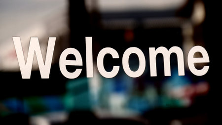 Welcome sign on a glass wall in a cafe with blurred background.の写真素材