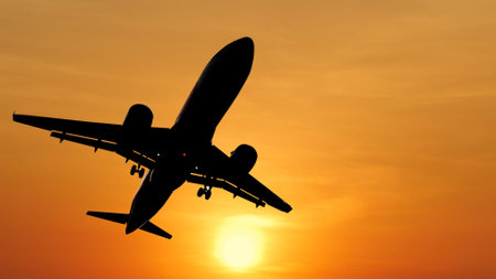 Silhouette of a passenger plane flying at sunset sky background.の写真素材