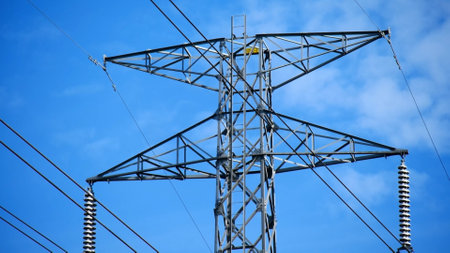 High voltage power lines and pylons against the blue sky.の写真素材