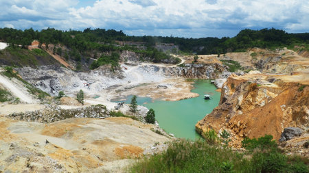 Aerial shot of an abandoned quarry featuring vibrant turquoise water, surrounded by rugged terrain...