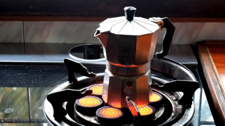 A classic moka pot brewing coffee on a gas stove, capturing the essence of a cozy kitchen atmosphere.の写真素材